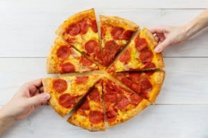 Sliced pizza being shared