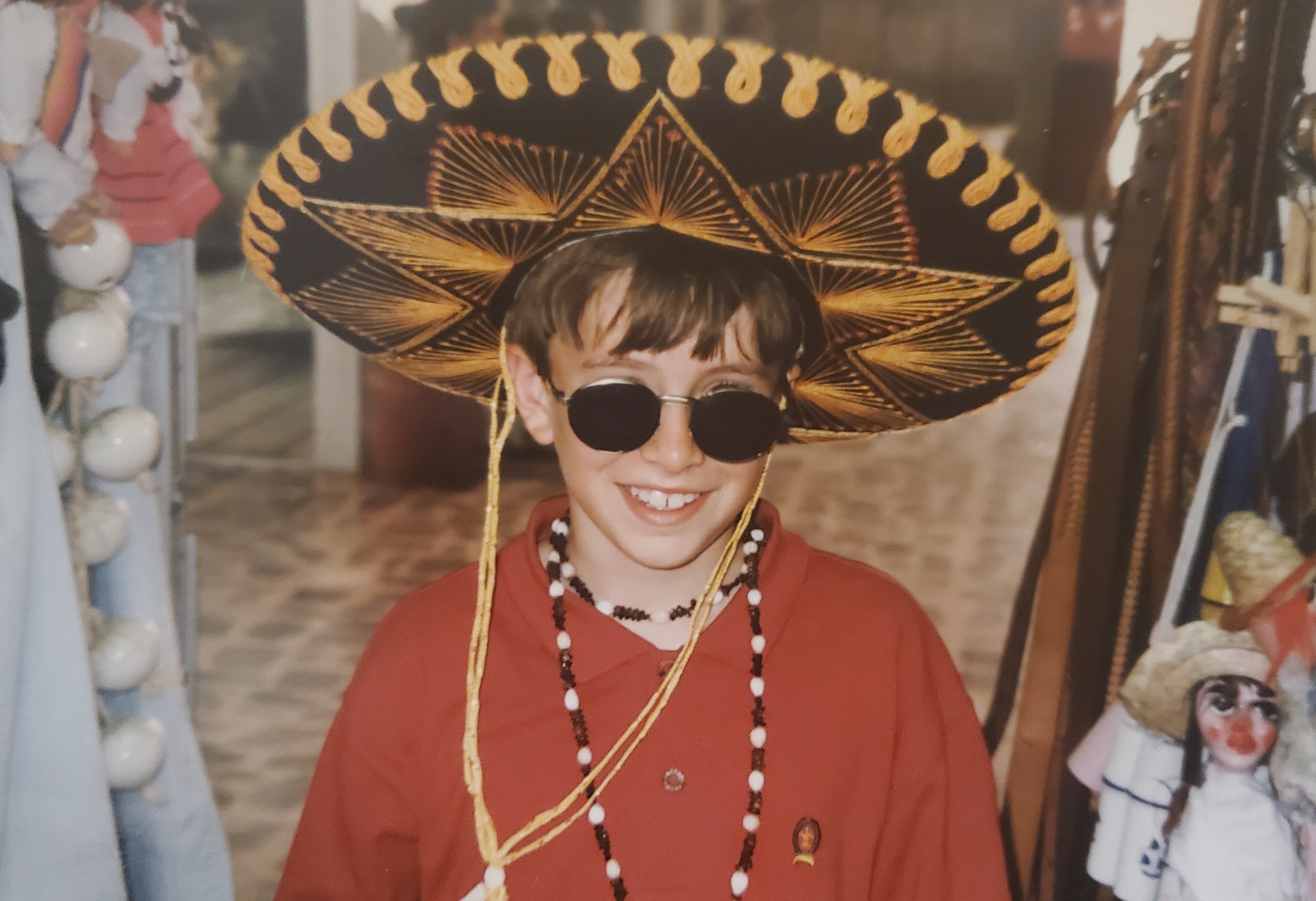 90s' kid wearing large sombrero and sunglasses