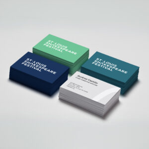 Four stacks of business cards are displayed. Three stacks, labeled "St. Louis Shakespeare Festival," are colored green, turquoise, and dark blue. A fourth stack features individual contact details for "Autumn Castillo, Chief Executive Officer," against a white backdrop.