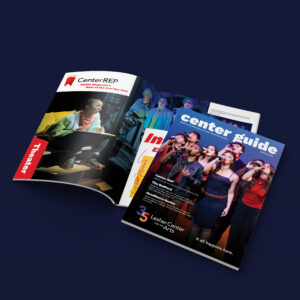 Two printed magazines, one open and one closed, featuring theater-related images, headlines, and vibrant colors on their covers and pages, displayed on a dark blue background.