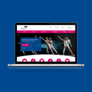 A laptop displays a performing arts center website featuring dancers on stage, with navigation links and a "Buy Tickets" button visible.